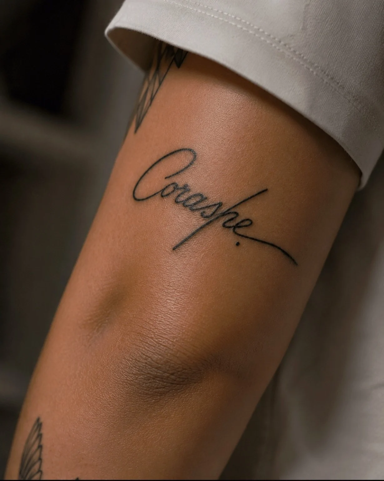 Lettering Corashe en el brazo, completo y en foco.
