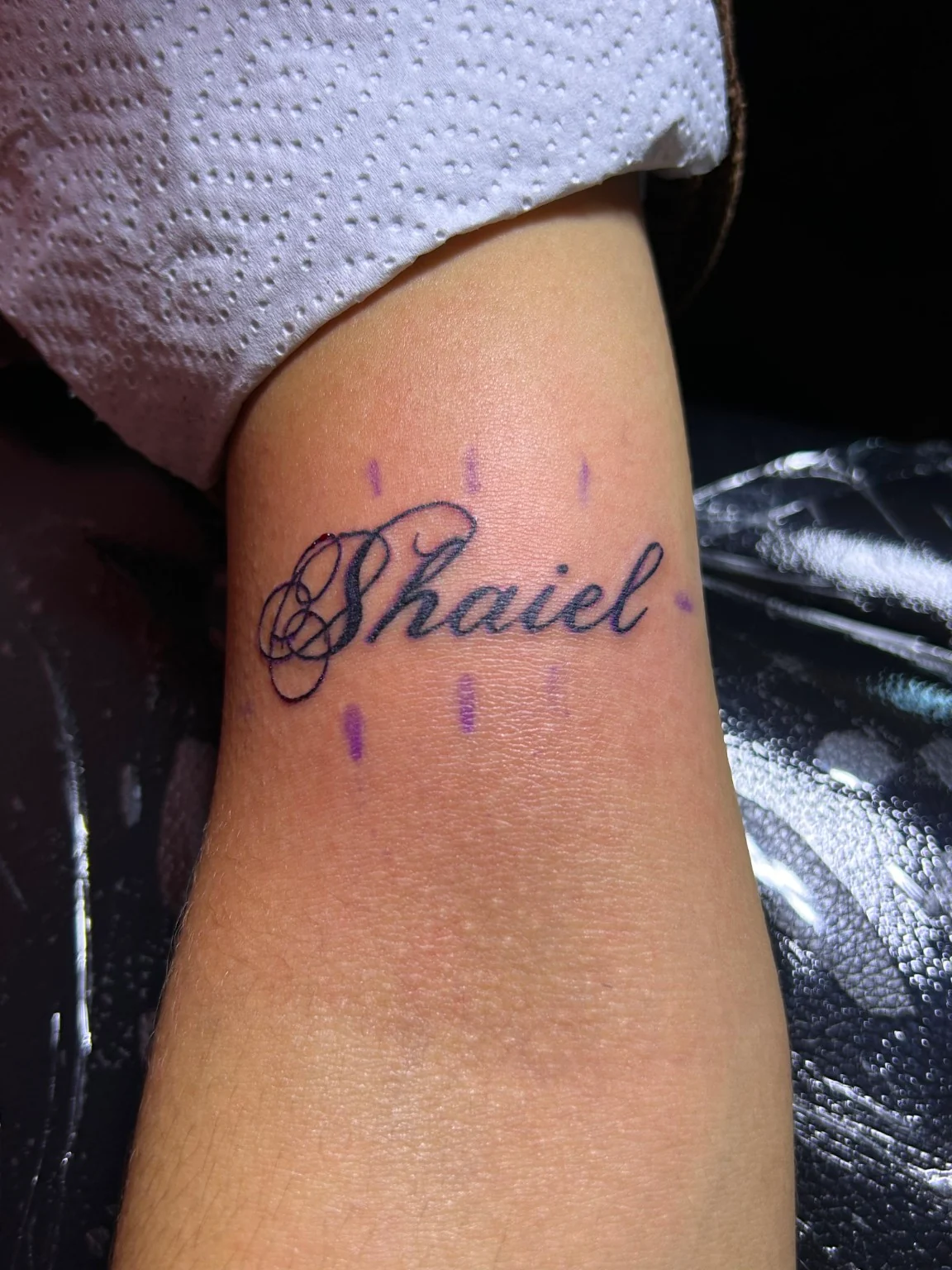 Nombre en caligrafía con una inicial ornamental y trazos negros.